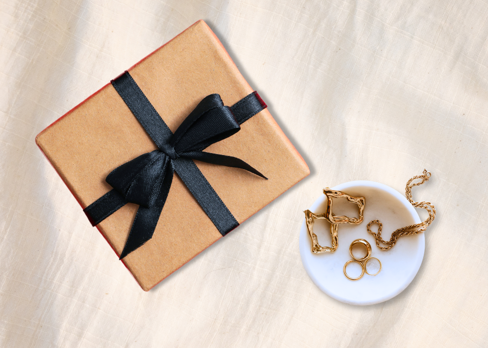 Rigid set-up box next to a bowl of jewelry